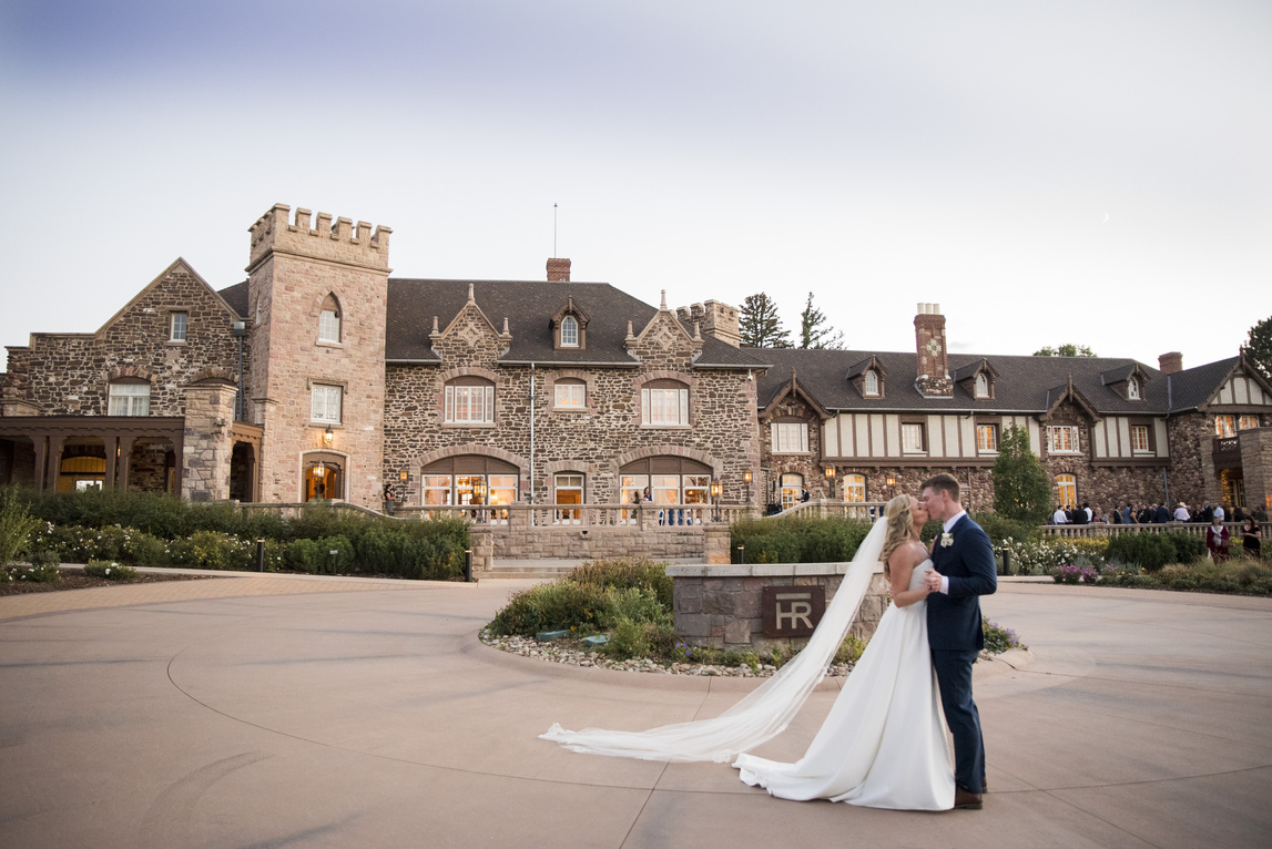 A bride and groom in front of the castle at Highlands Ranch Mansion.
