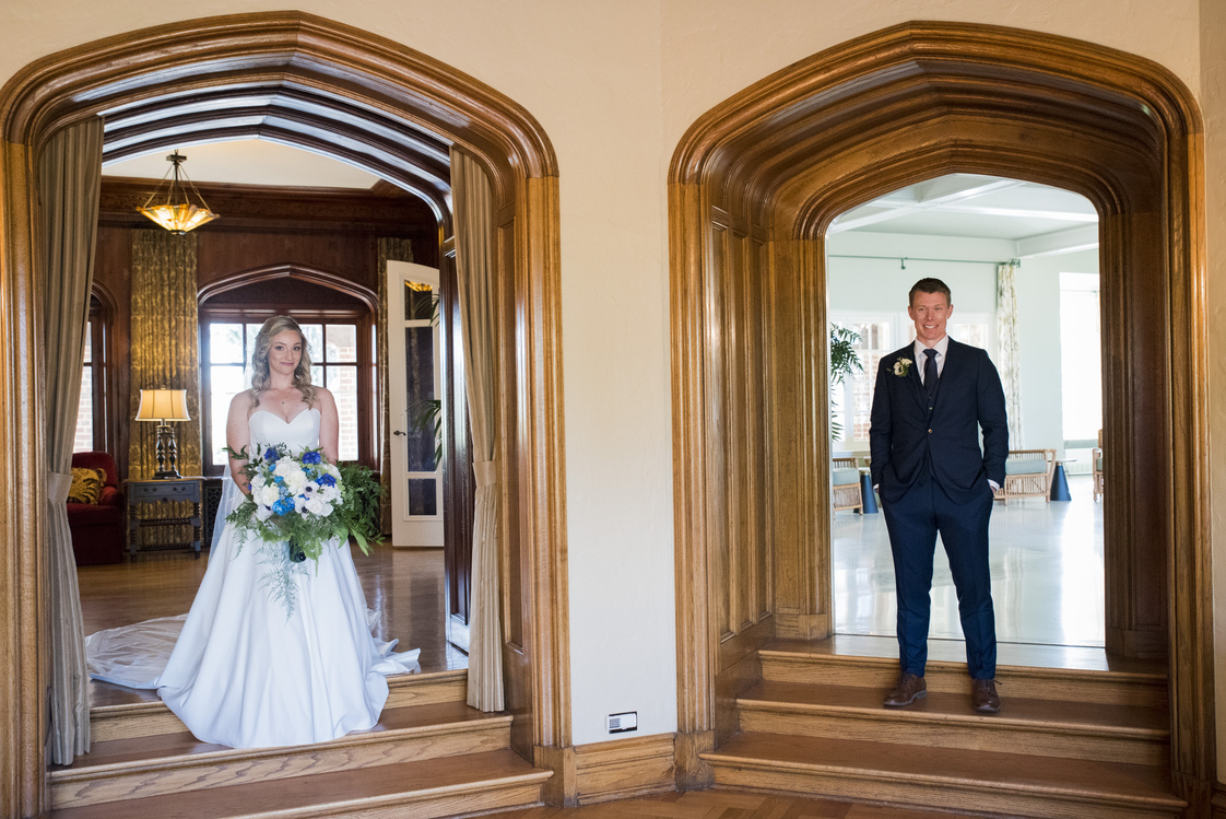 bride and groom standing in front of ornate archway