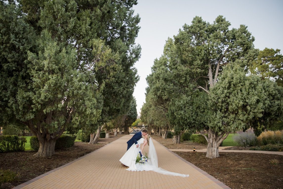A bride and groom kissing in the garden at Highlands Ranch Mansion.